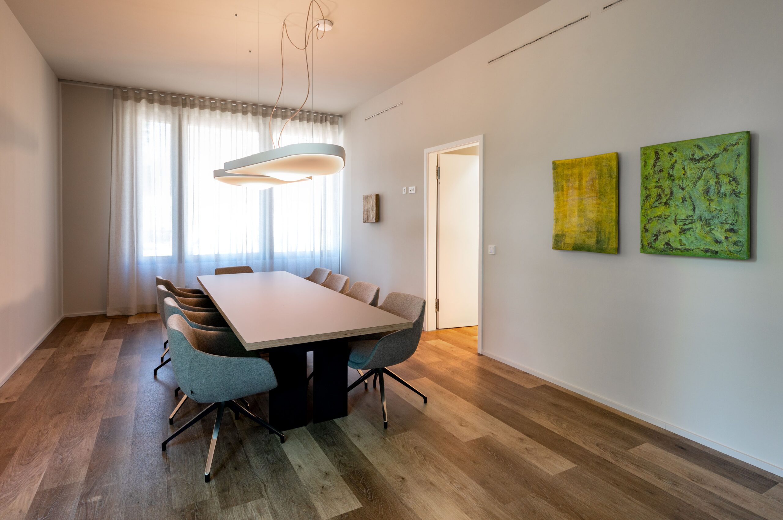 Heller Konferenzraum der mamonova Praxis in Lindenthal mit großem Besprechungstisch, modernen Stühlen, natürlichem Tageslicht und stilvoller Wandgestaltung.